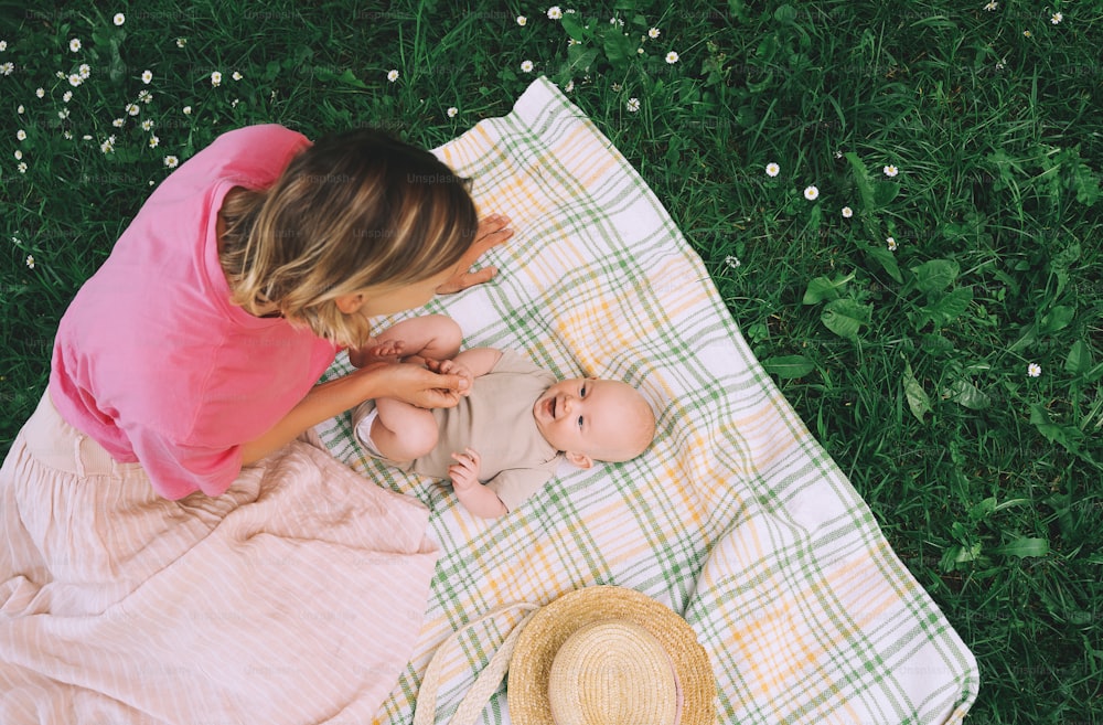 Beautiful mother and baby on nature. Young woman with her baby in harmony. Concept of natural motherhood, human happiness, healthy family, eco sustainable lifestyle. Loving mom with child outdoors.