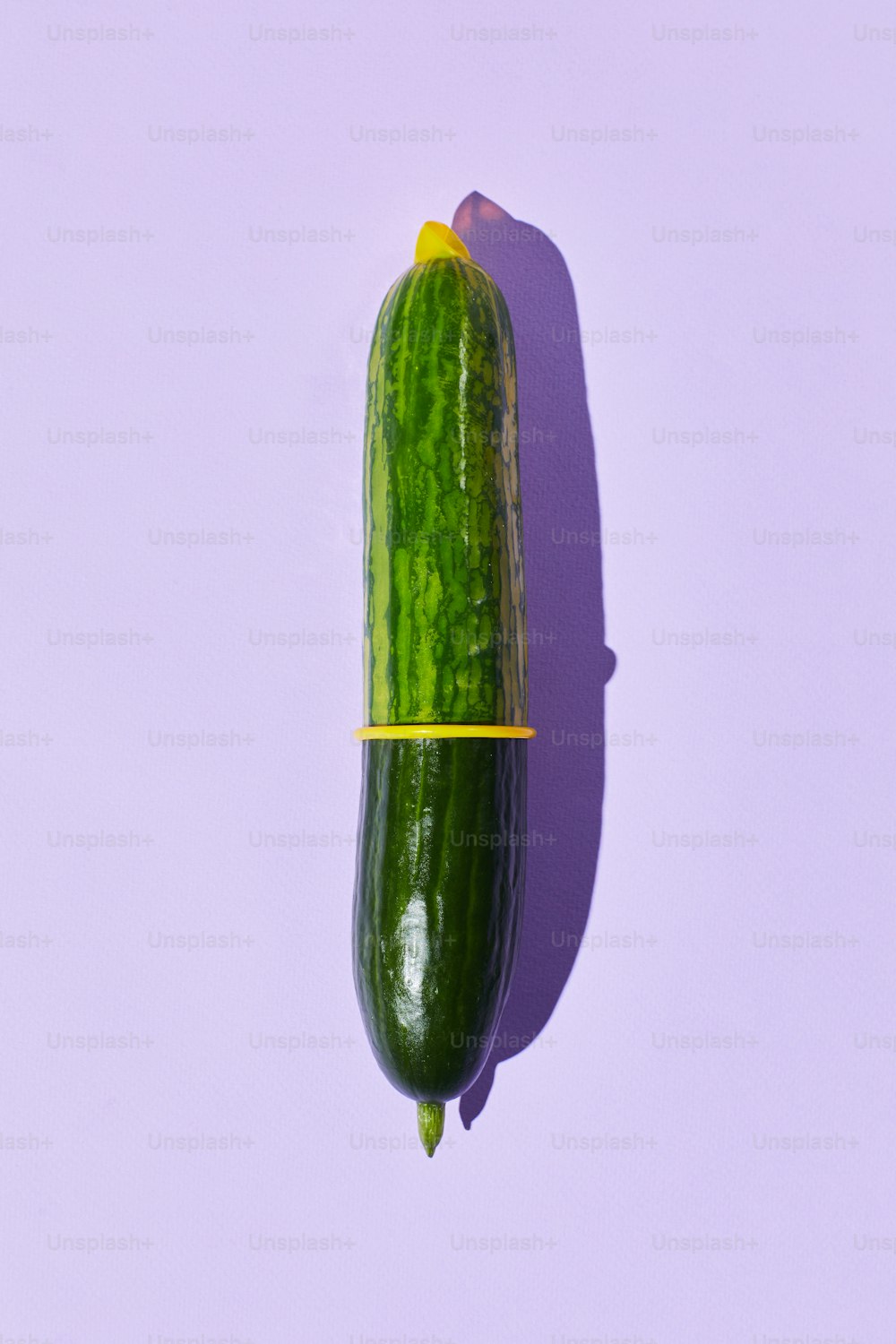 Minimal shot of single cucumber with condom on pastel background safe sex and protection concept