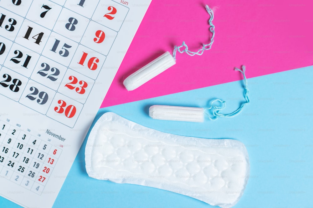 Protección de la higiene de la mujer, calendario de la menstruación y tampones y compresas de algodón limpios