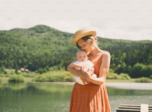 Mère et bébé. Concept de maternité naturelle et de maternité. Belle femme et petit bébé heureux ensemble dans un fond de nature verte. Maman aimante avec enfant à l’extérieur.