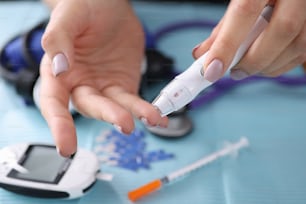 Woman drawing blood with lancet at home closeup. Blood glucose control in diabetes mellitus concept