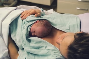 Mutter und Neugeborenes. Geburt eines Kindes in der Entbindungsklinik. Junge Mutter umarmt ihr neugeborenes Baby nach der Geburt. Gebärende Frau. Die ersten Momente des Babylebens nach den Wehen.