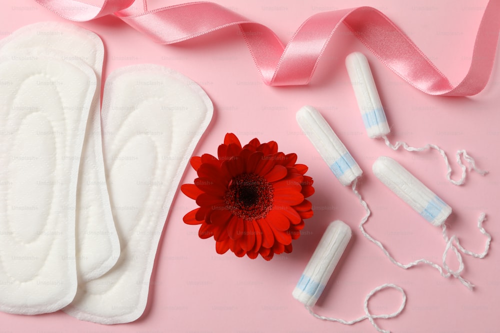 Concepto del período de la menstruación sobre fondo rosa, vista superior