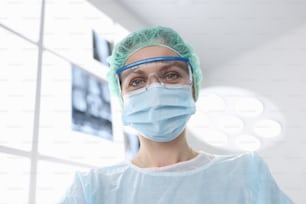 Donna chirurgo in tuta sterile in sala operatoria. Concetto di assistenza sanitaria