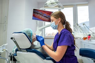 jovem mulher bonita veio para a prestigiada nova odontologia para tratar os dentes em seu próprio dentista. O conceito de tratamento de cuidado da cavidade de trabalho dos dentes.