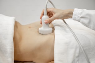 Mujer durante un examen ecográfico de la cavidad abdominal, primer plano. Concepto de salud y exploración durante el embarazo