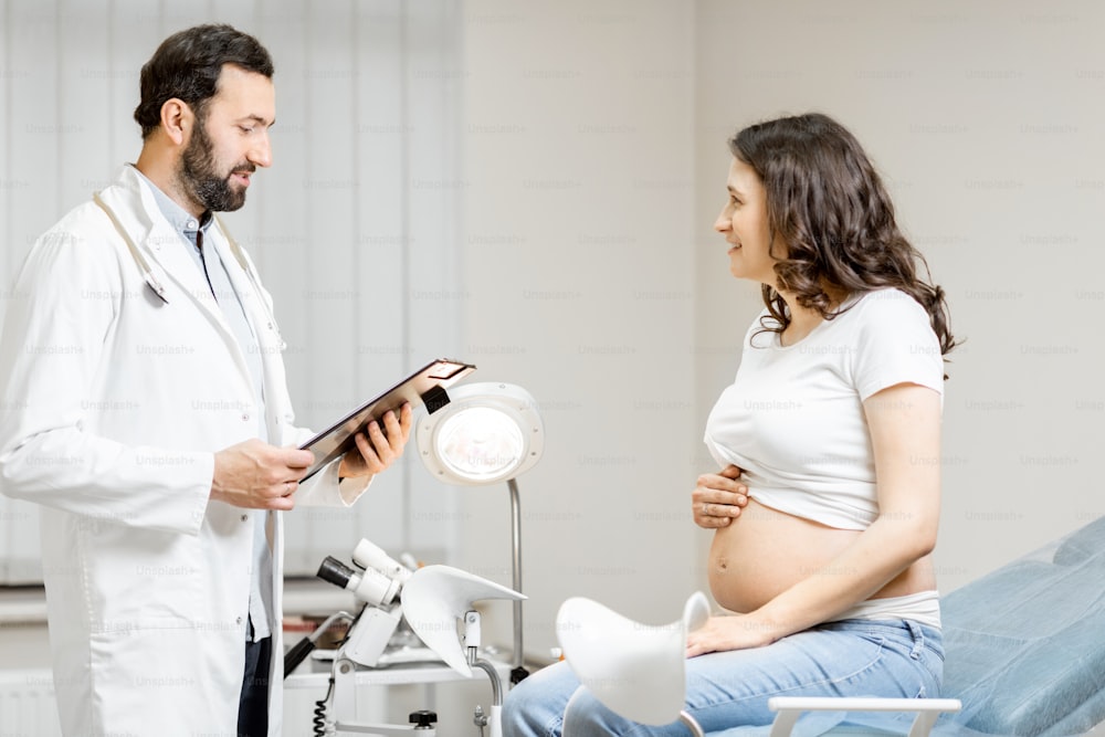부인과 진료실에서 진찰 중인 임산부와 함께하는 의사. 임신 중 의료와 건강의 개념