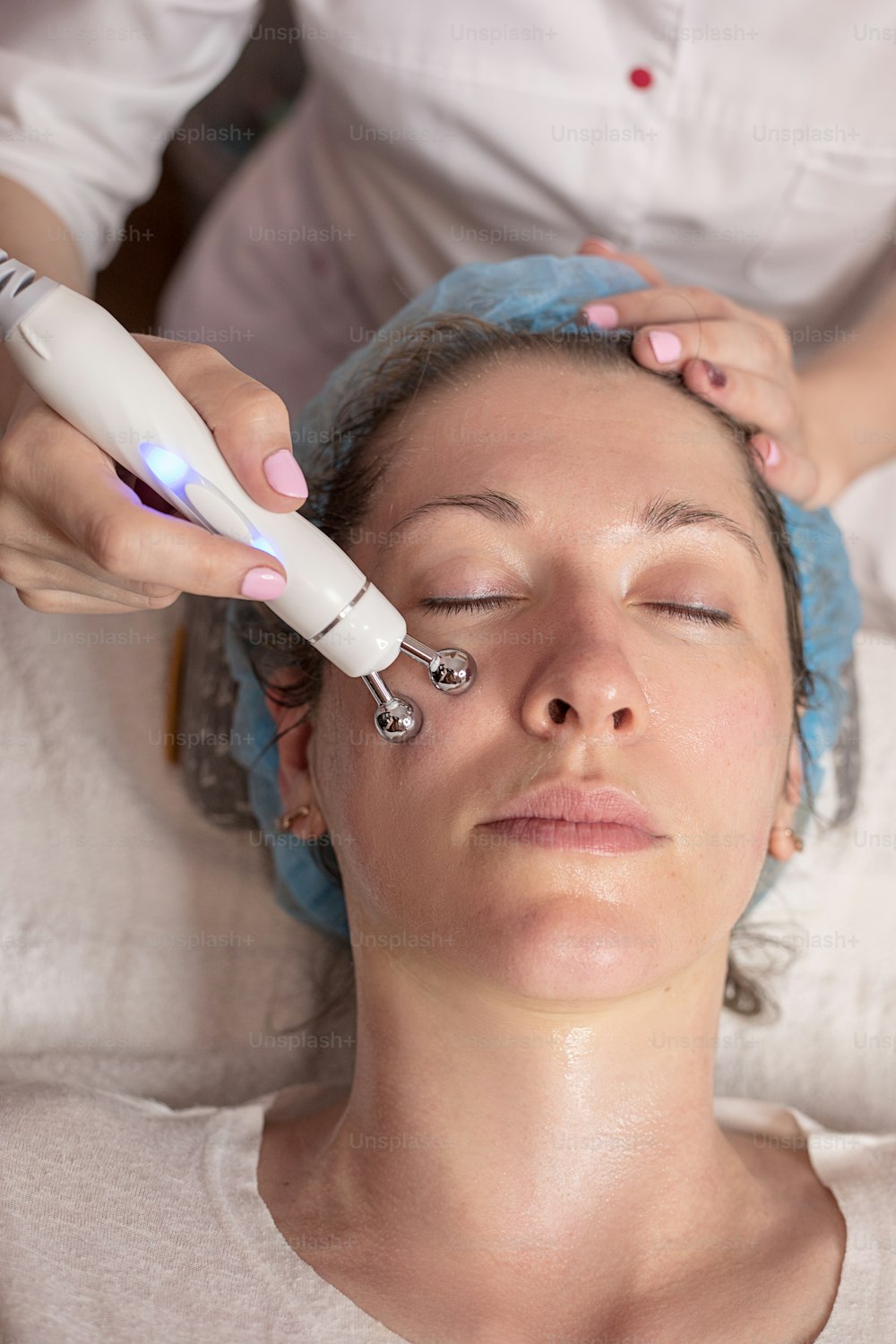 A young woman gets a beauty treatment at the hydro peeling care Spa. Beauty tools. Facial or beautician specialist. Photo