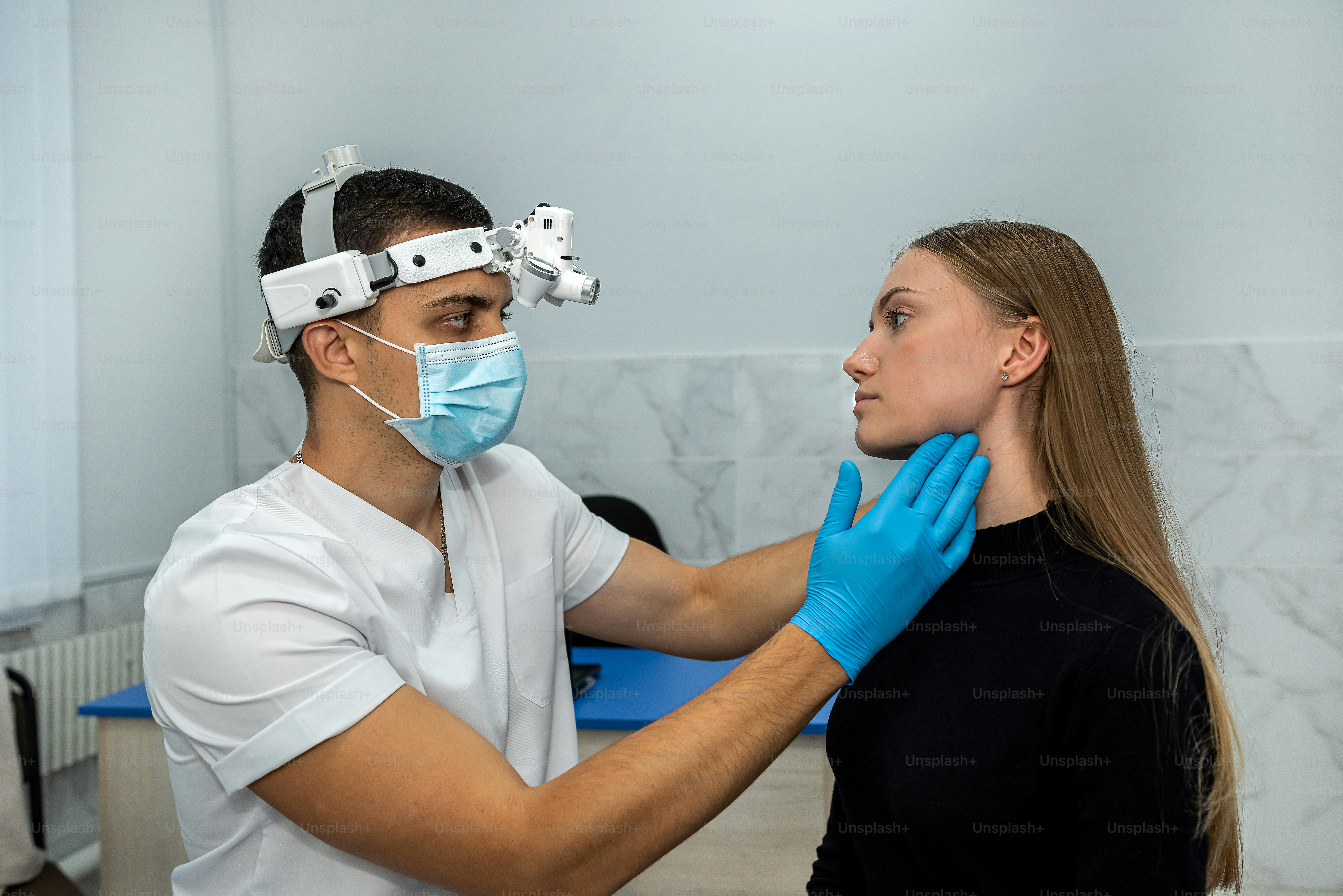 doctor examines the throat of a female patient who has opened her mouth to check her throat. medicine.