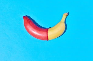 Colpo vibrante di una singola banana con preservativo su sfondo blu caldo sesso sicuro e concetto di protezione, spazio di copia