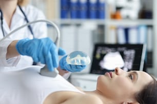 Exame de ultrassonografia mamária após aumento com implantes. Suspeita de violação da integridade dos implantes e conceito de deformidade mamária