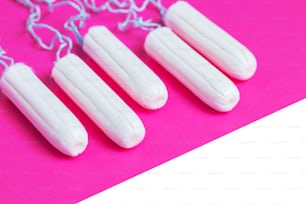 Concepto de período menstrual. Protección de la higiene de la mujer. Tampones de algodón sobre fondo rosa. espacio de copia.