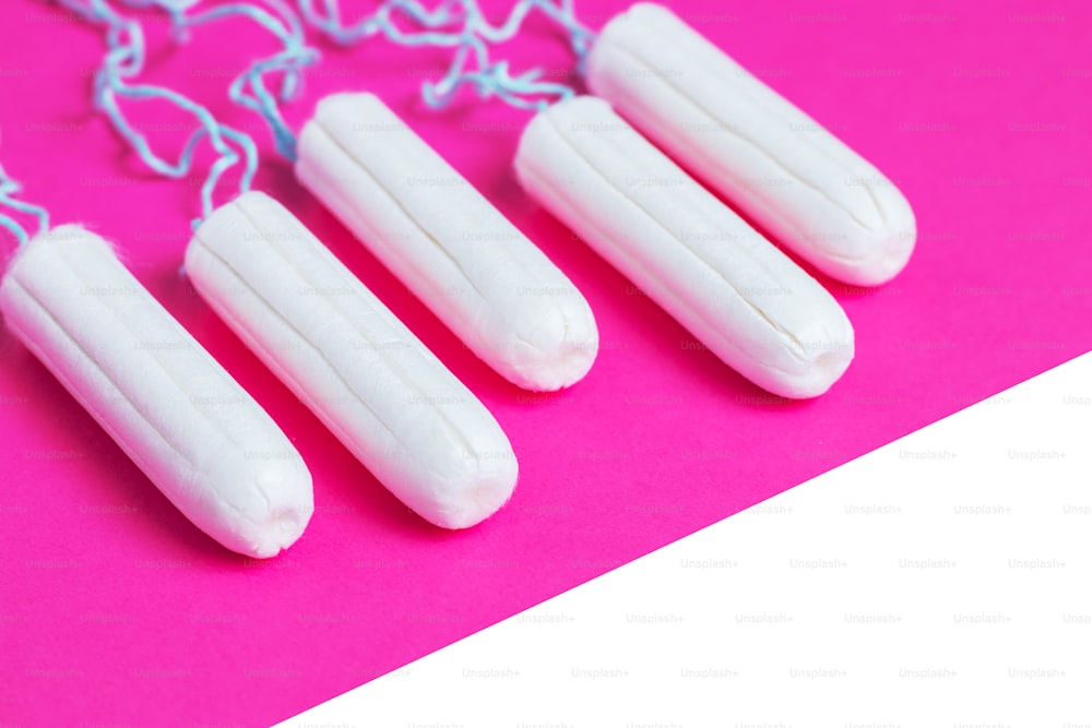 Menstruations-Konzept. Hygieneschutz für Frauen. Baumwolltampons auf rosa Hintergrund. Kopierbereich.