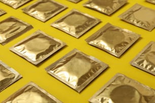 Flat Lay mit leeren Kondomen auf gelbem Hintergrund