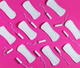 Tampones, patrón de toallas sanitarias femeninas sobre fondo rosa. Cuidados higiénicos durante los días críticos. Ciclo menstrual. Cuidar la salud de la mujer. Protección mensual.
