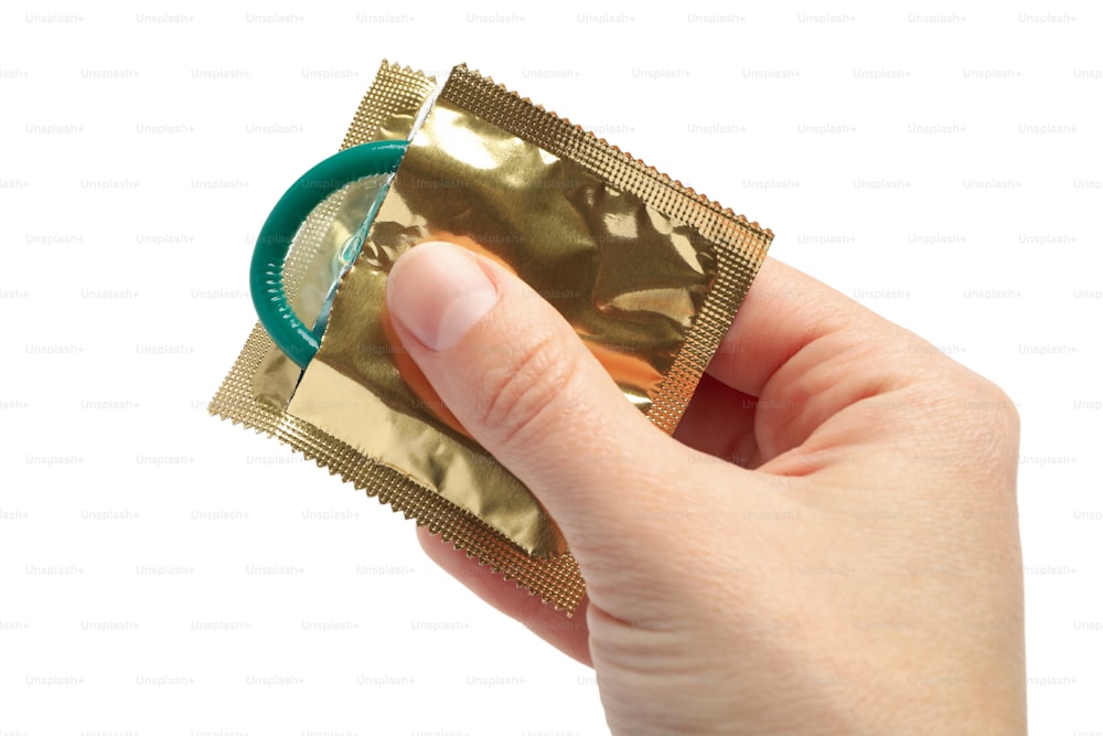Female hand hold condom, isolated on white background