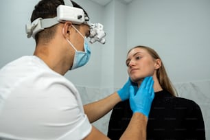 young female patient came to see a ENT doctor with throat problems. the doctor makes an examination.