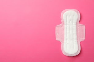 Sanitary pad on pink background, top view