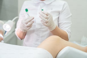 Il ginecologo fa un'iniezione. L'attraente medico ginecologo tratta il paziente