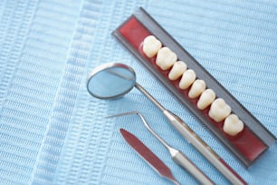 Primer plano del conjunto de herramientas médicas del dentista para tratar los problemas de los dientes de las personas. Espejo diminuto, muestra de dientes en la superficie. Gabinete de estomatología, odontología, concepto bucal