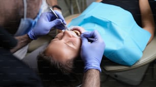 歯科医院で女性患者に虫歯のある歯を治療します。歯のコンセプトのケアと治療