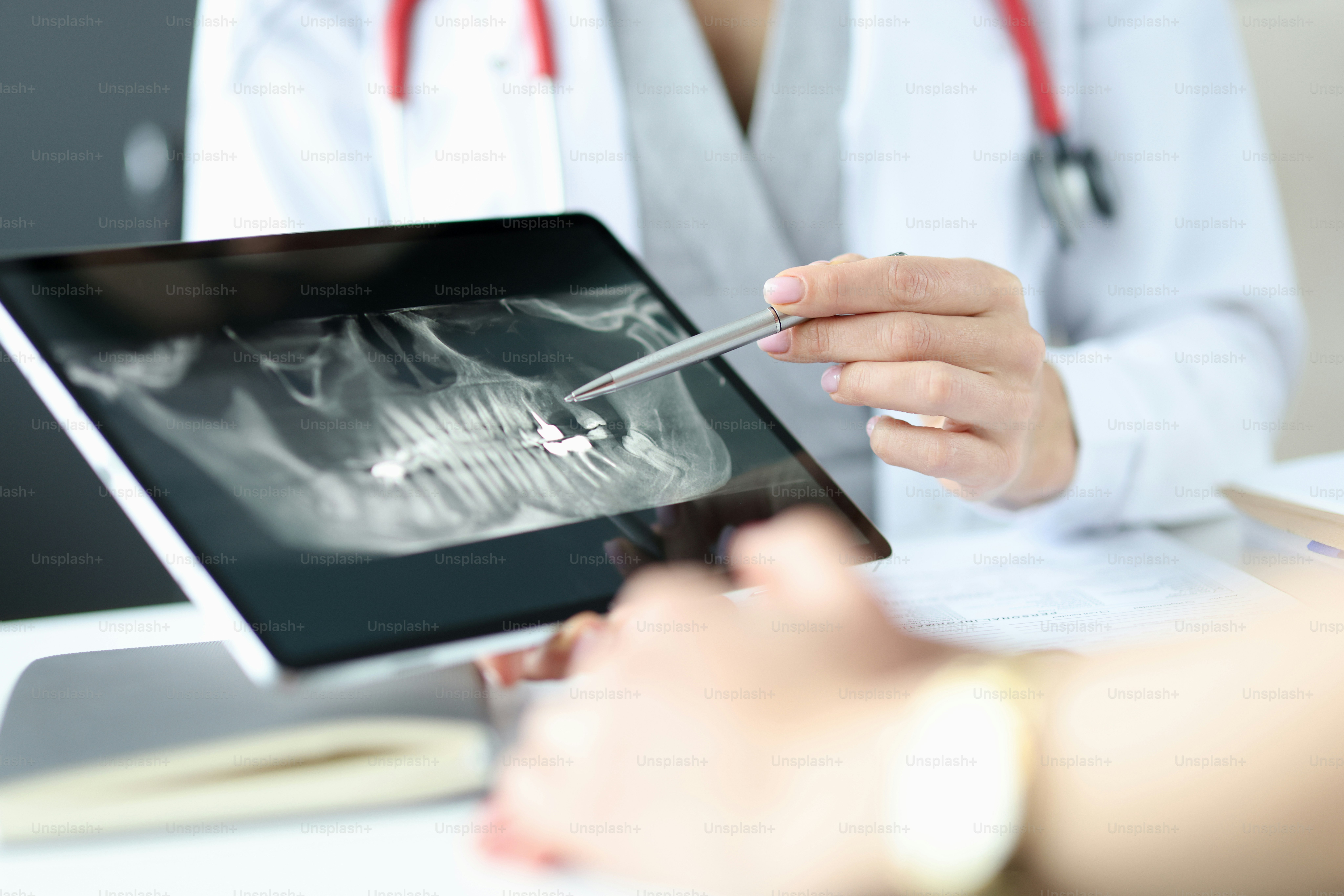 Dentist shows an X-ray of jaw to patient on tablet. Dentist services concept