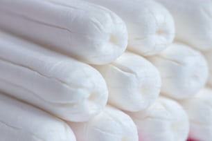 Medical female tampon close up. Hygienic white tampon for women. Cotton swab. Menstruation, means of protection. Tampons on a red background.