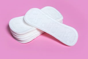 Feminine hygiene pads on a pink background. Concept of feminine hygiene during menstruation