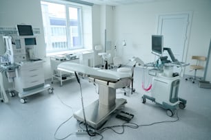 병원의 부인과 의자, 초음파 기계 및 다양한 의료 장비가 있는 캐비닛 내부