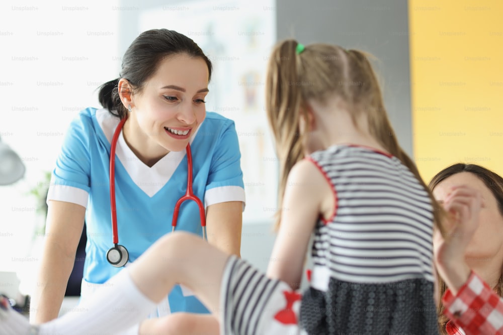 클리닉에서 약속 시간에 어린 소녀를 진찰하는 여성 의사. 어린이를 위한 의료 개념