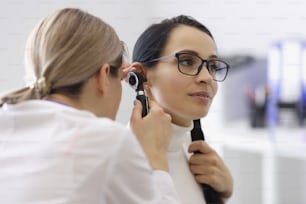 Retrato do médico verificar a orelha dos pacientes no exame médico com ferramenta especial. Consulta em clínica de otorrinolaringologista especialista. Conceito de saúde