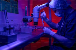 Un scientifique de laboratoire biologique effectue un test immuno-enzymatique, prélevant des échantillons de sang dans des éprouvettes