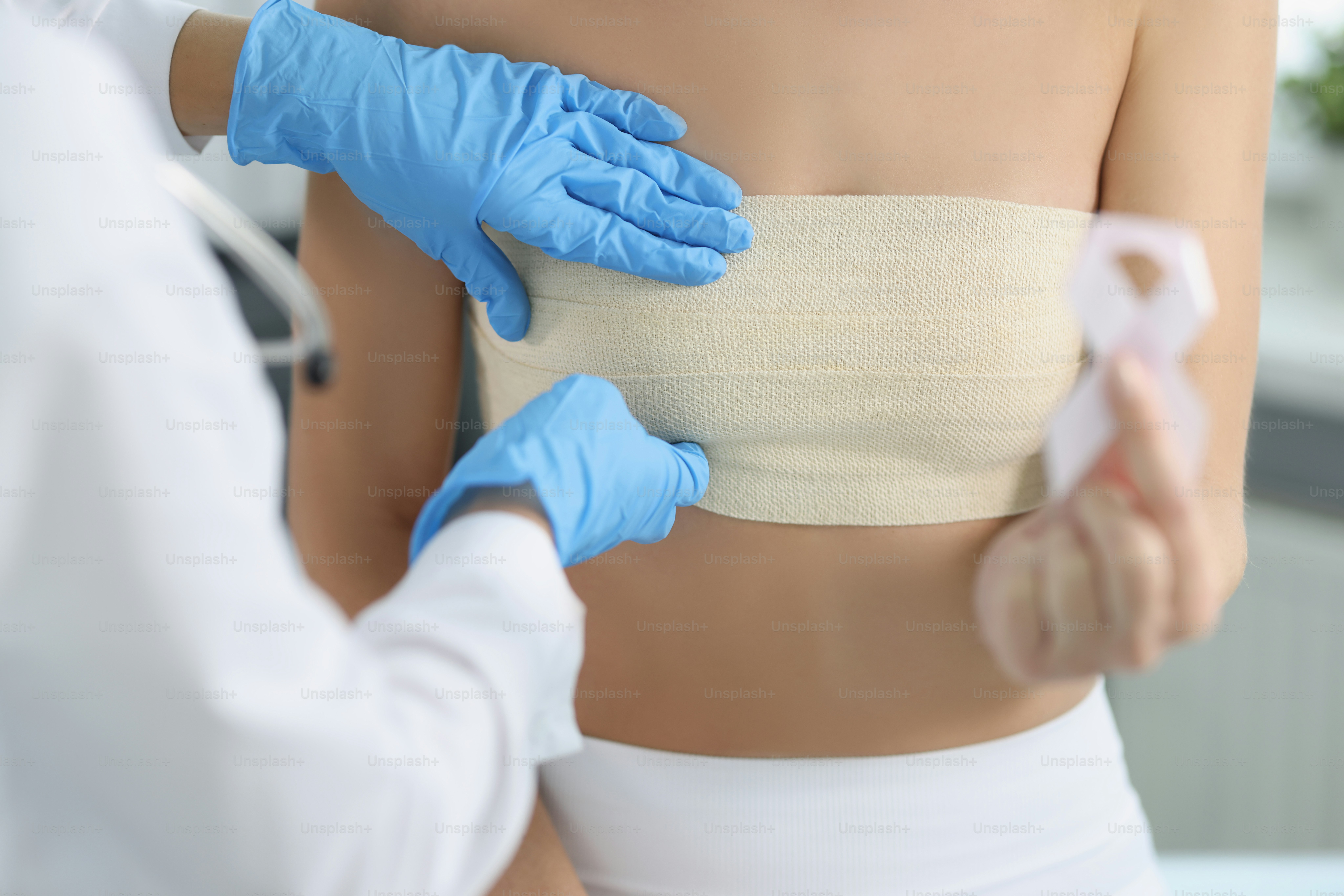 Primo piano della donna tiene il simbolo del nastro bianco del cancro al seno, diagnosi tempestiva, supporto dei pazienti oncologici. Ospedale, mammografia, cancro, concetto di controllo