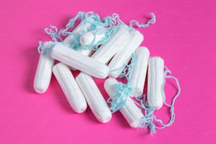 Tampão feminino médico close up em um fundo rosa. Tampão branco higiênico para mulheres. Cotonete. Menstruação, meios de proteção. Tampões em um fundo vermelho.
