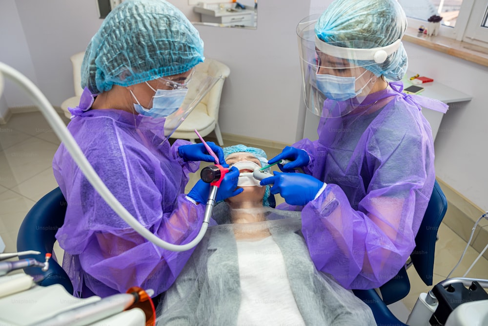 Un dentiste compétent et son assistante effectuent l’opération au cabinet pour installer un implant dentaire. Concept de dentisterie