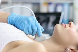Die Frau erhält Ultraschall der Schilddrüse vom Arzt. Schilddrüsenhormone und Schilddrüse