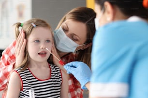 Médico tomando swab de pcr do nariz da menina usando cotonete na clínica. Conceito de diagnóstico de covid em crianças