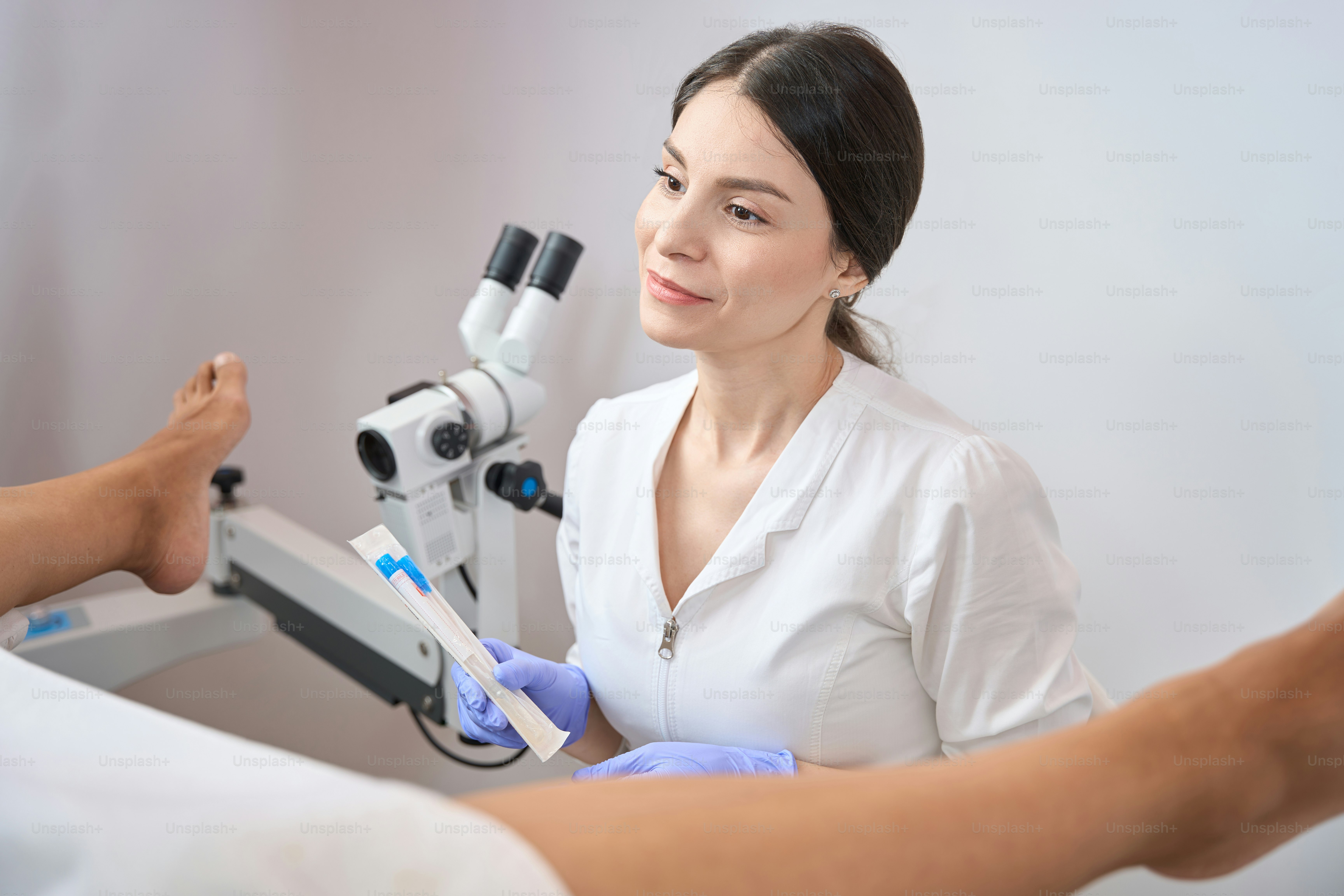 Smiling lady gynecologist is holding in her hands a set for taking biomaterial from the vagina for analysis