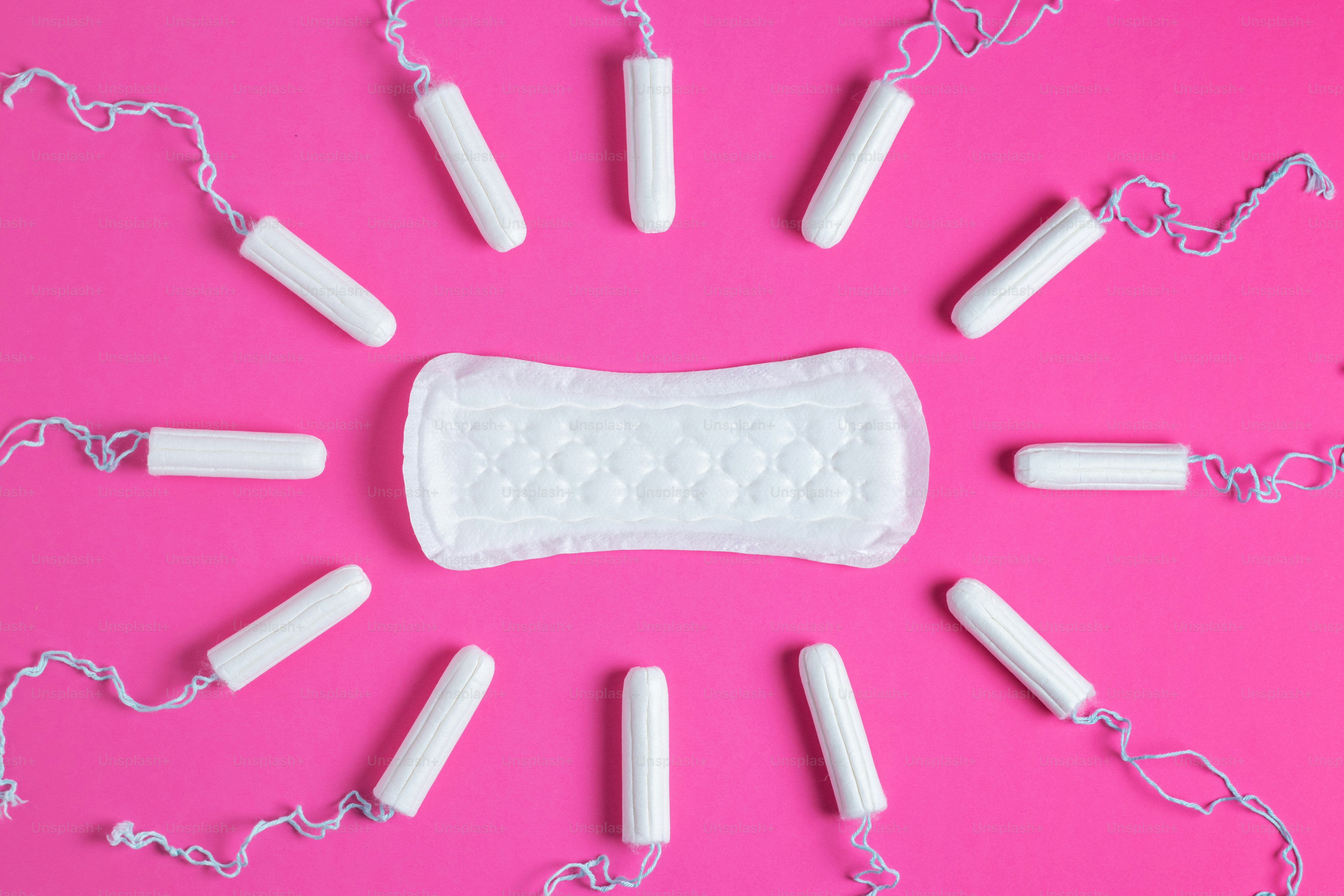 Menstrual tampons and pads on a pink background. Menstruation cycle