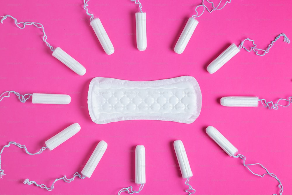 Tampões menstruais e absorventes em um fundo rosa. Ciclo menstrual. Higiene e proteção. espaço de cópia.