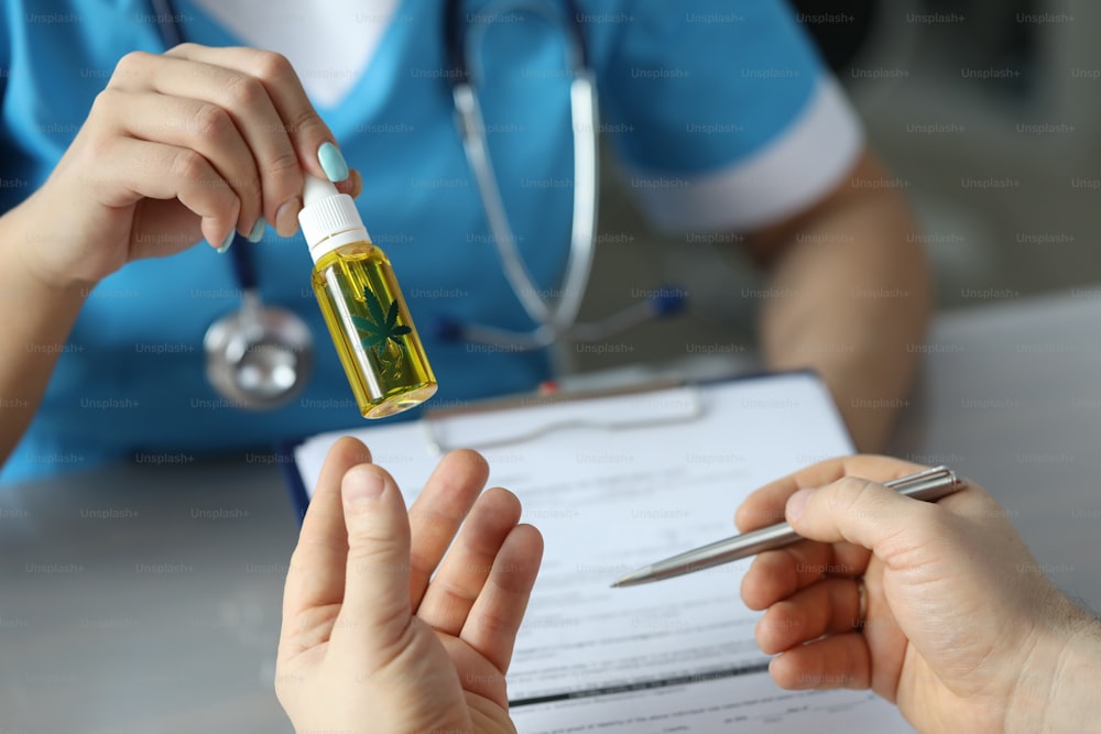 Doctor prescribes cannabis extract closeup to patient. Legal cannabinoid treatment concept.