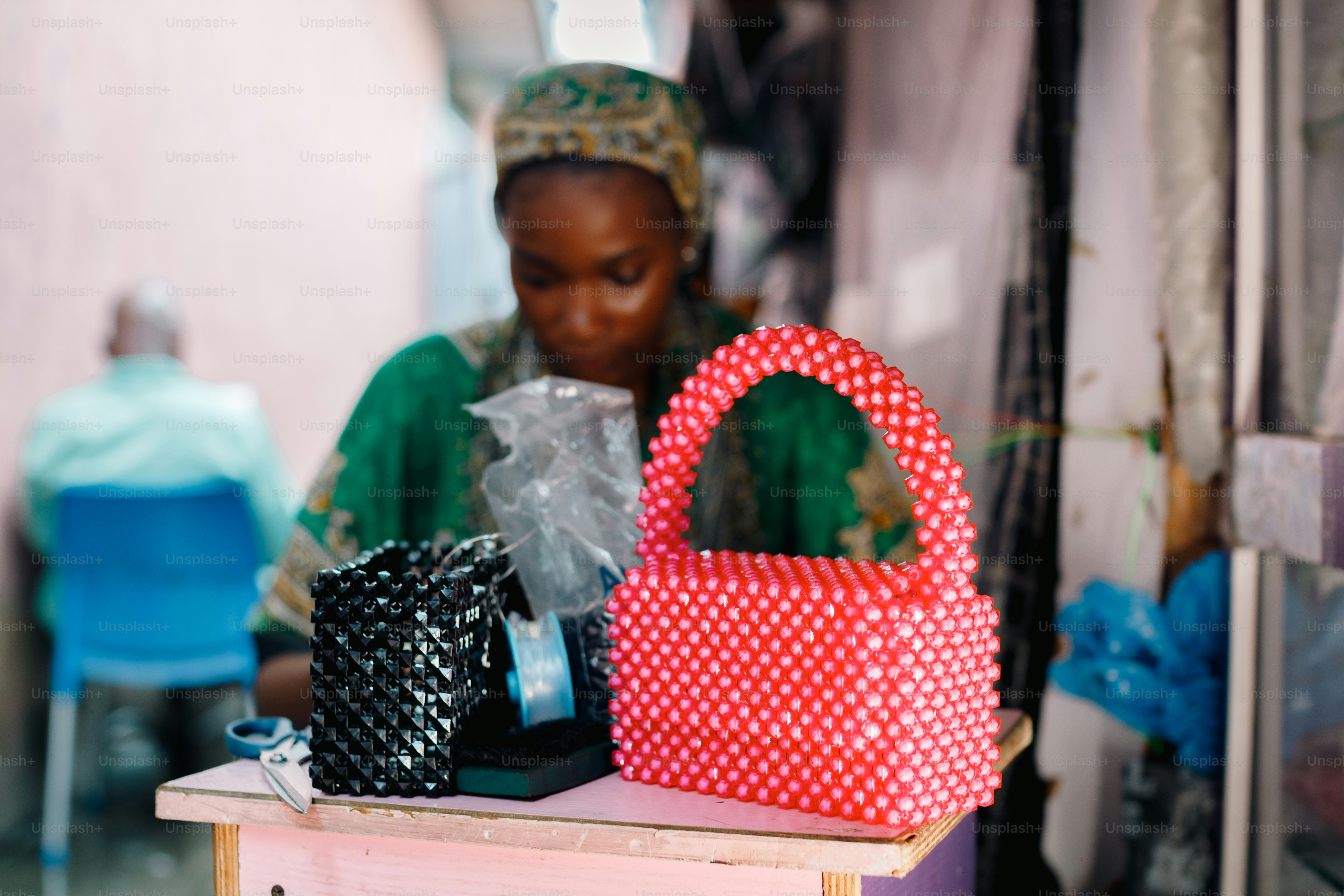 a woman sitting at a table with a red and white purse