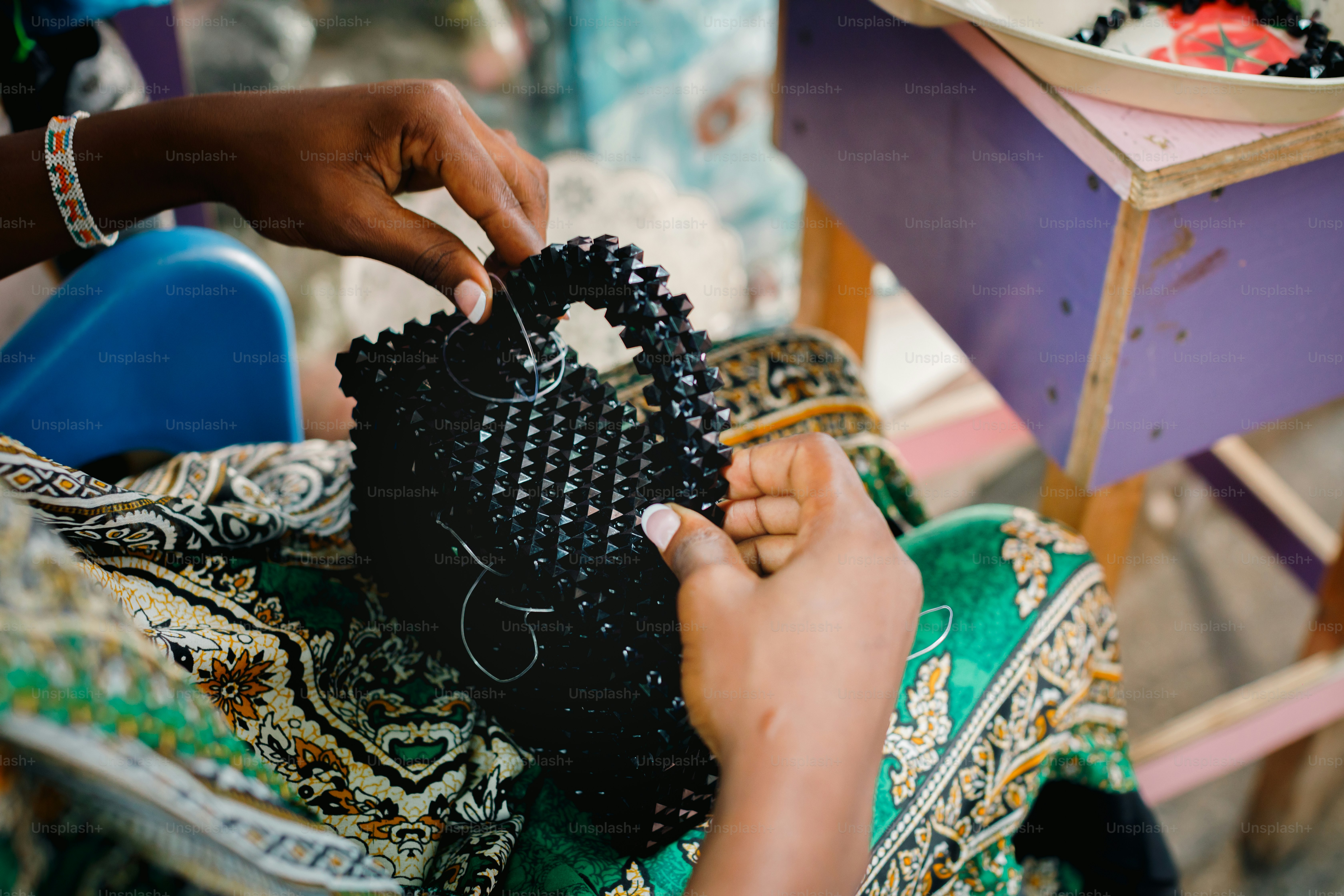 a woman is working on a piece of fabric