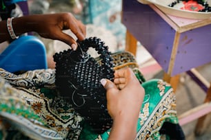 a woman is working on a piece of fabric