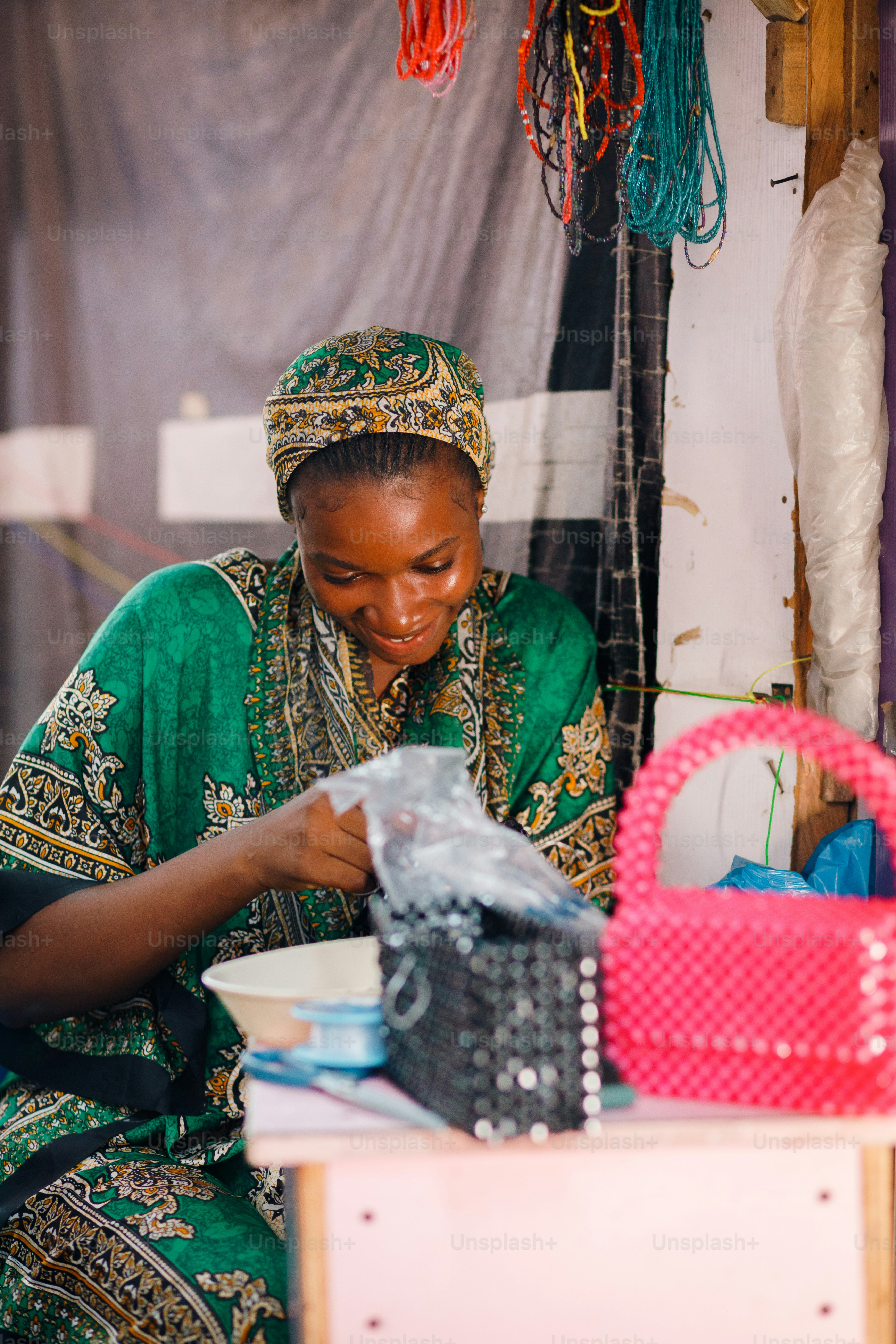 a woman in a green and gold dress is looking at a bag