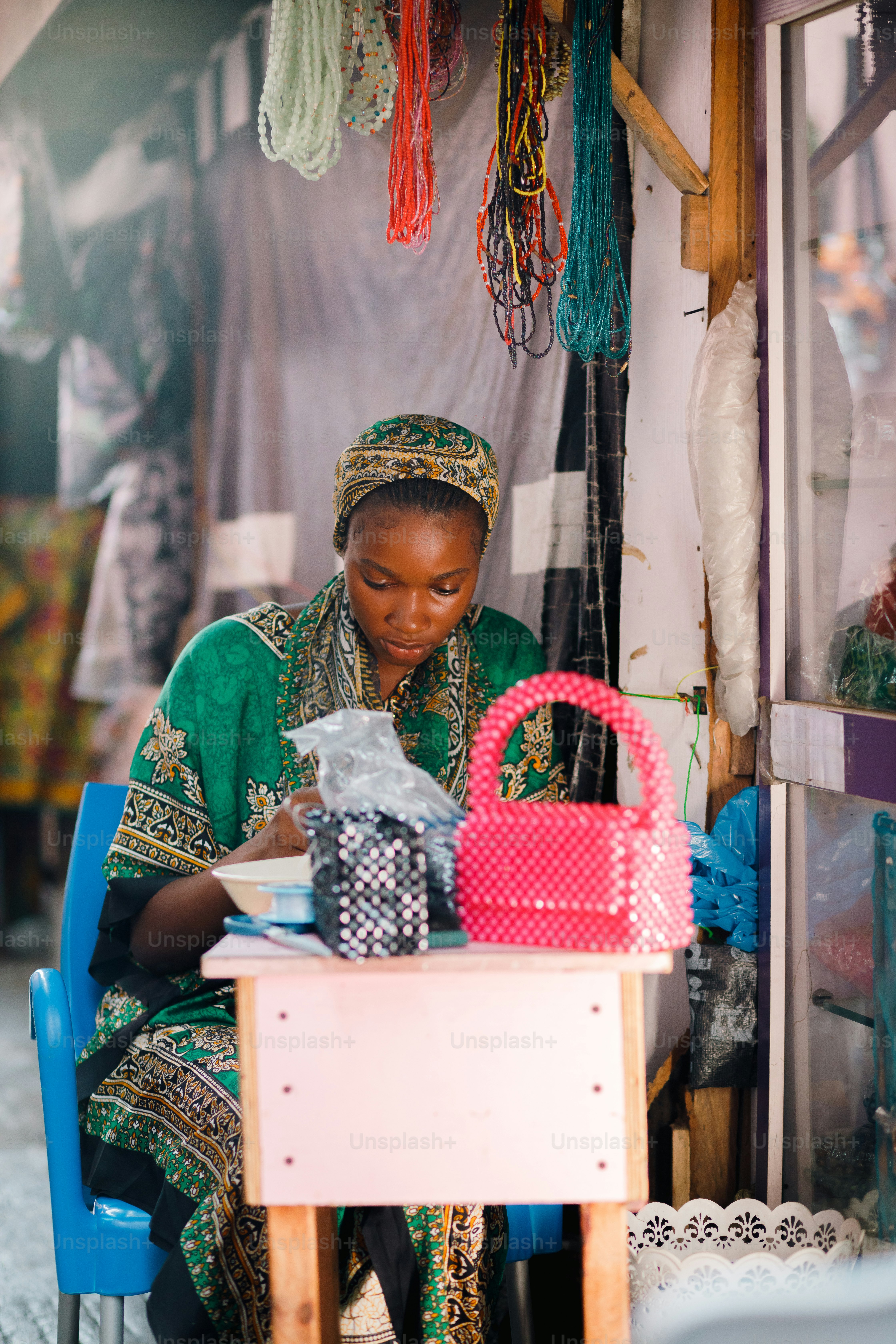 a woman sitting at a table working on a piece of paper