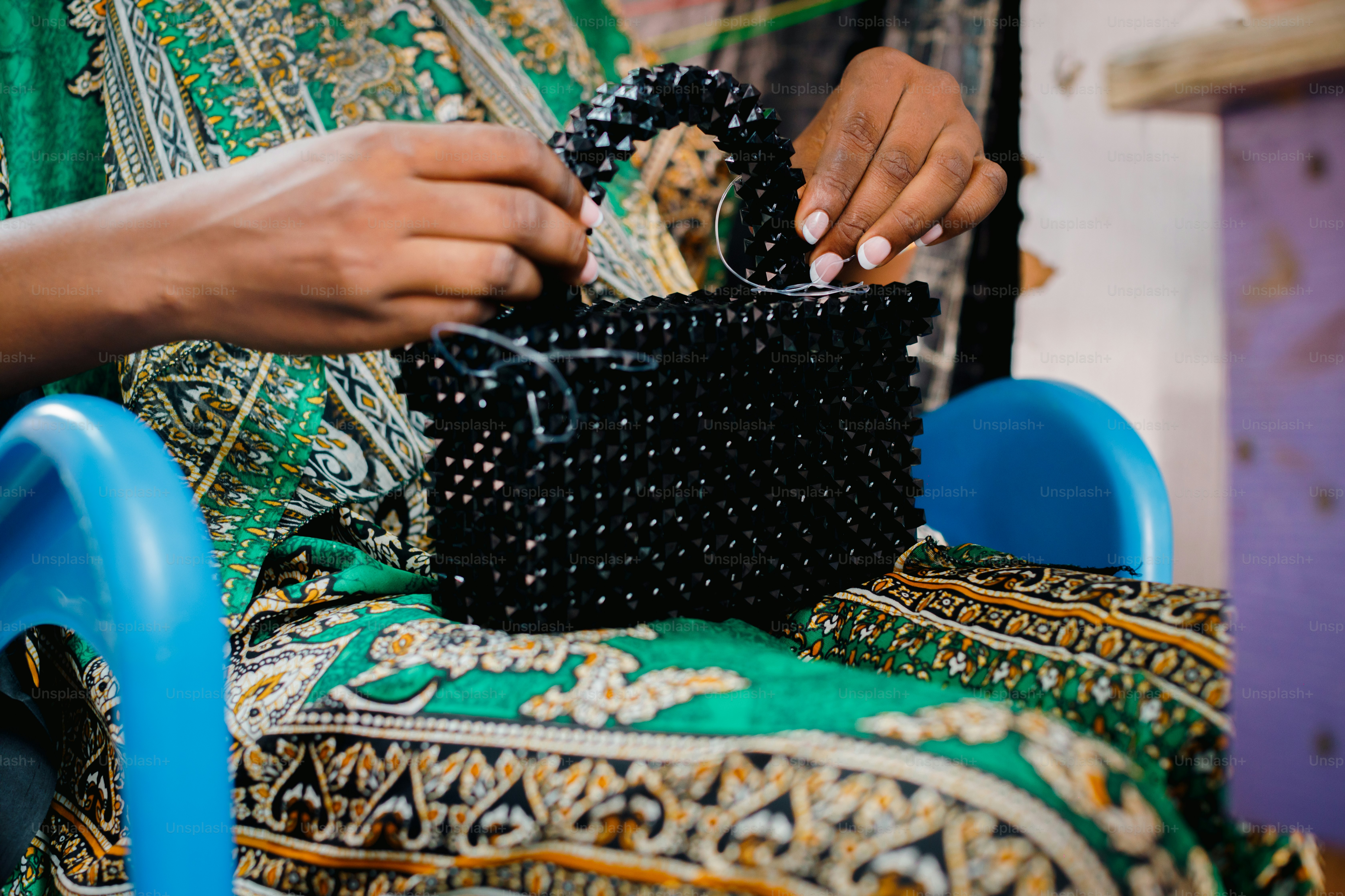 a woman holding a black purse on top of a blue chair