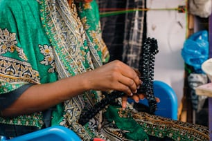 a woman sitting in a chair working on a piece of art