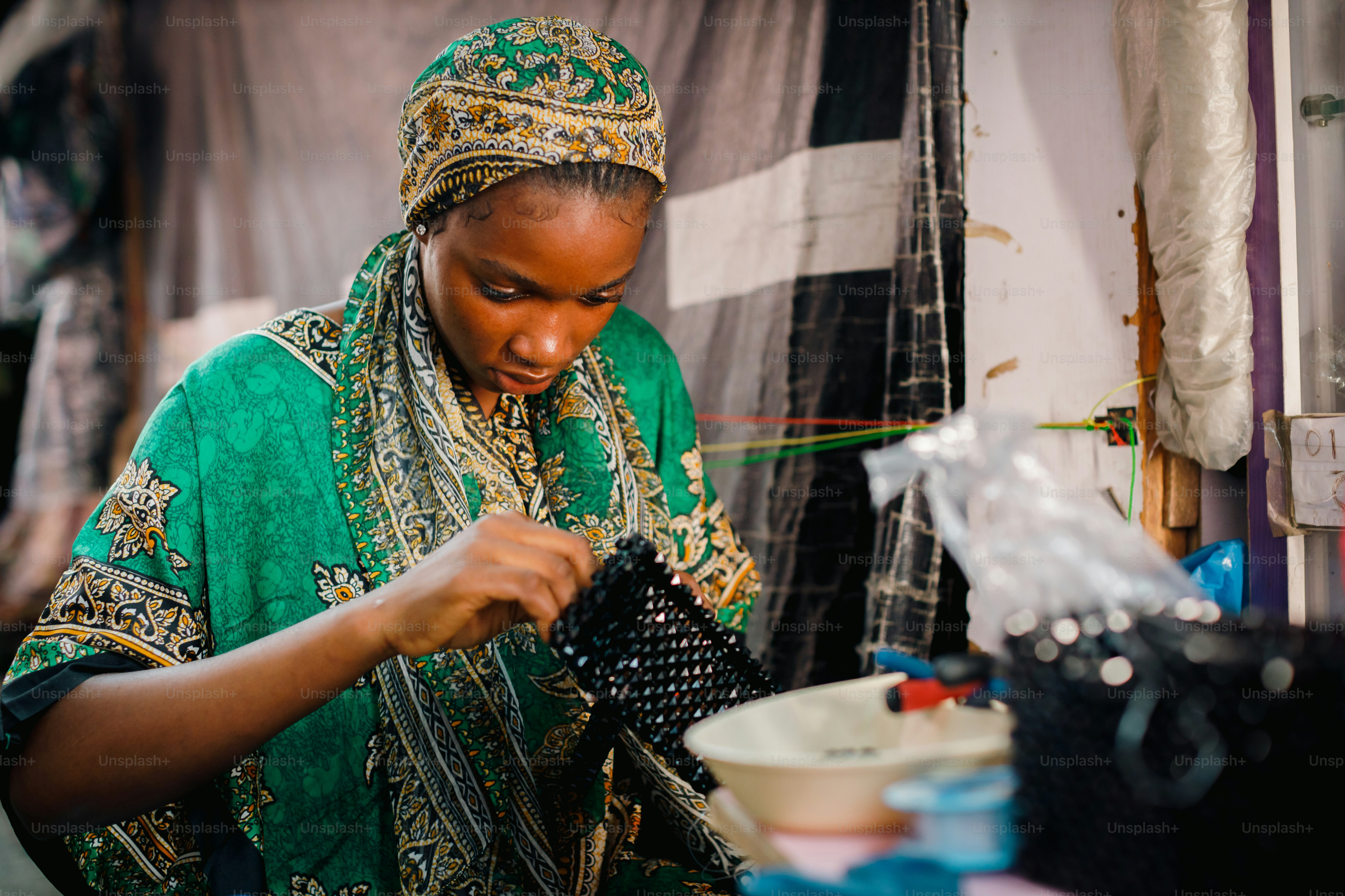 a woman in a green and gold dress is working on something