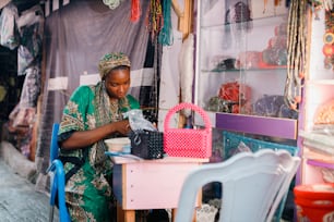 a woman is working on a bag in a shop